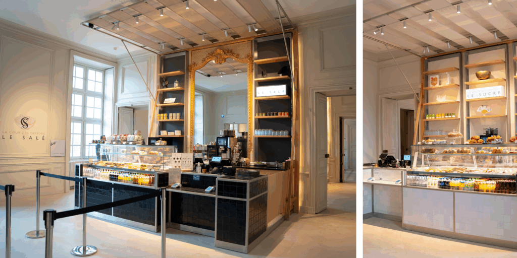 Interior de La Cour des Saveurs en el Château de Versailles con mostradores gastronómicos franceses y visitantes degustando productos gourmet