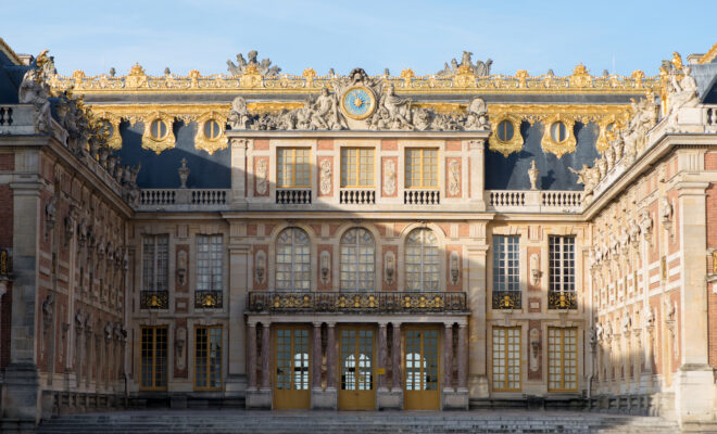 Interior de La Cour des Saveurs en el Château de Versailles con mostradores gastronómicos franceses y visitantes degustando productos gourmet